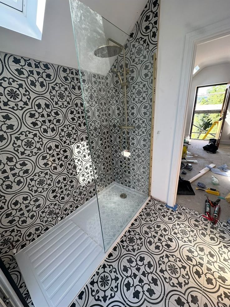 Walk-in shower with patterned black and white tiles