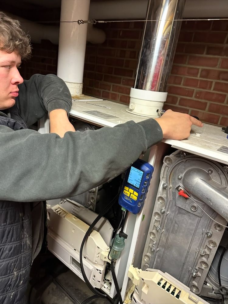 George testing a boiler with a flue gas analyser connected