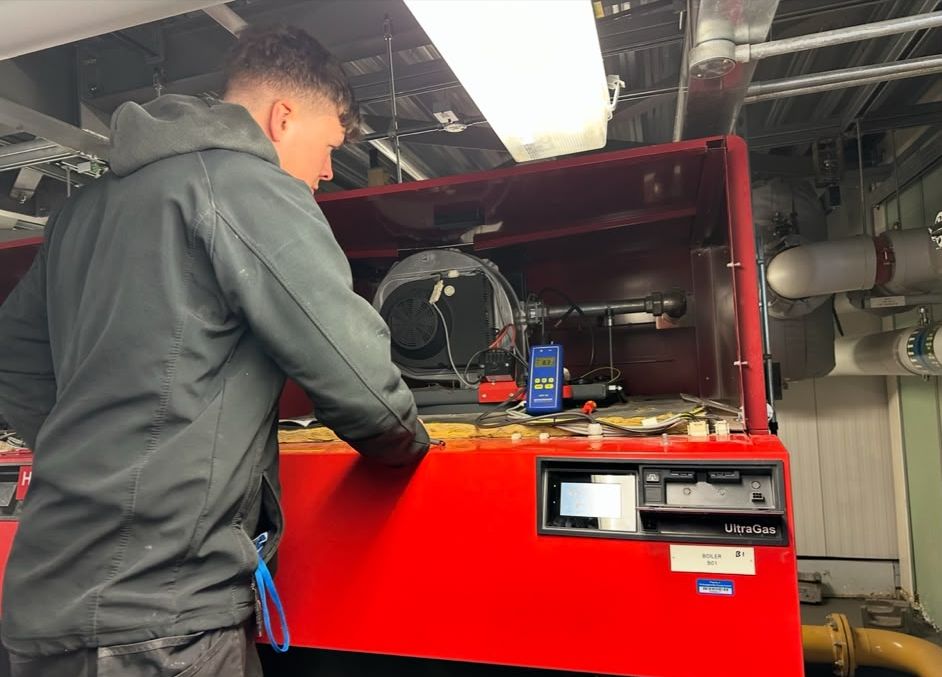 George working on a large commercial boiler with test equipment